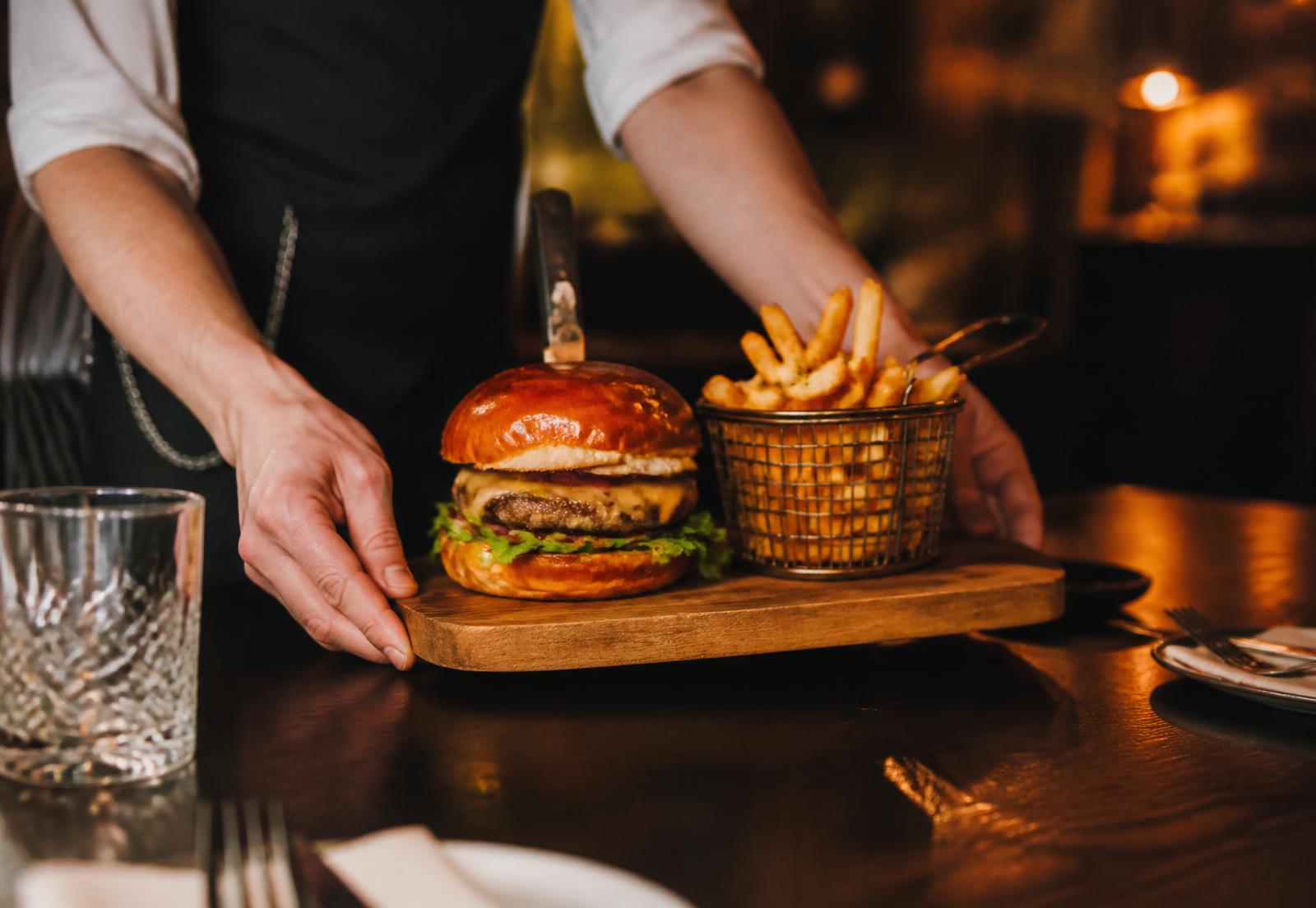 Burger e batata sendo servidos na mesa